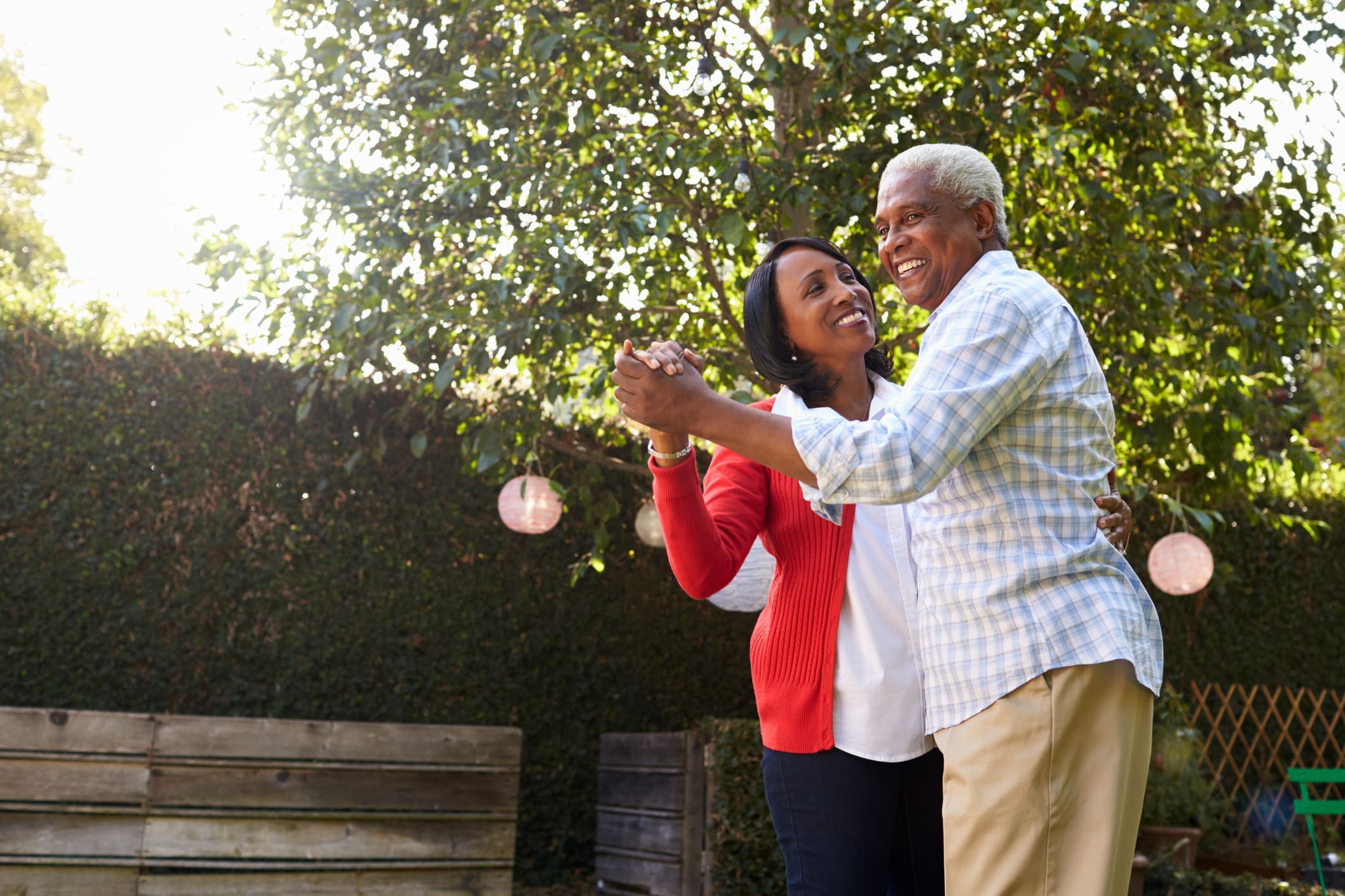 Senior couple dancing in their back garden